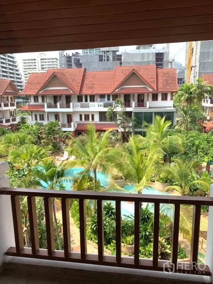 Townhouse for rent in Watthana, Bangkok - Balcony view over a palm-filled courtyard and a freeform pool.