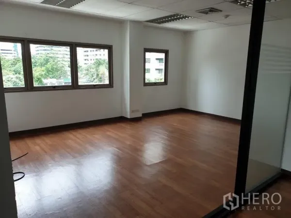 办公空间 出租在Khlong Toei, Bangkok - 角落办公室，木地板，多扇窗户可见绿景