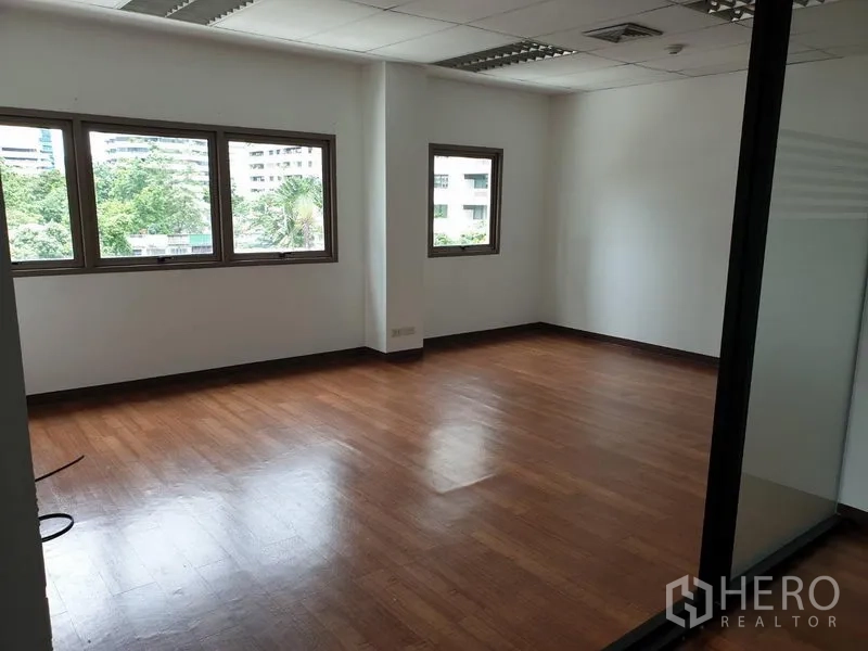 办公空间 出租在Khlong Toei, Bangkok - 角落办公室，木地板，多扇窗户可见绿景