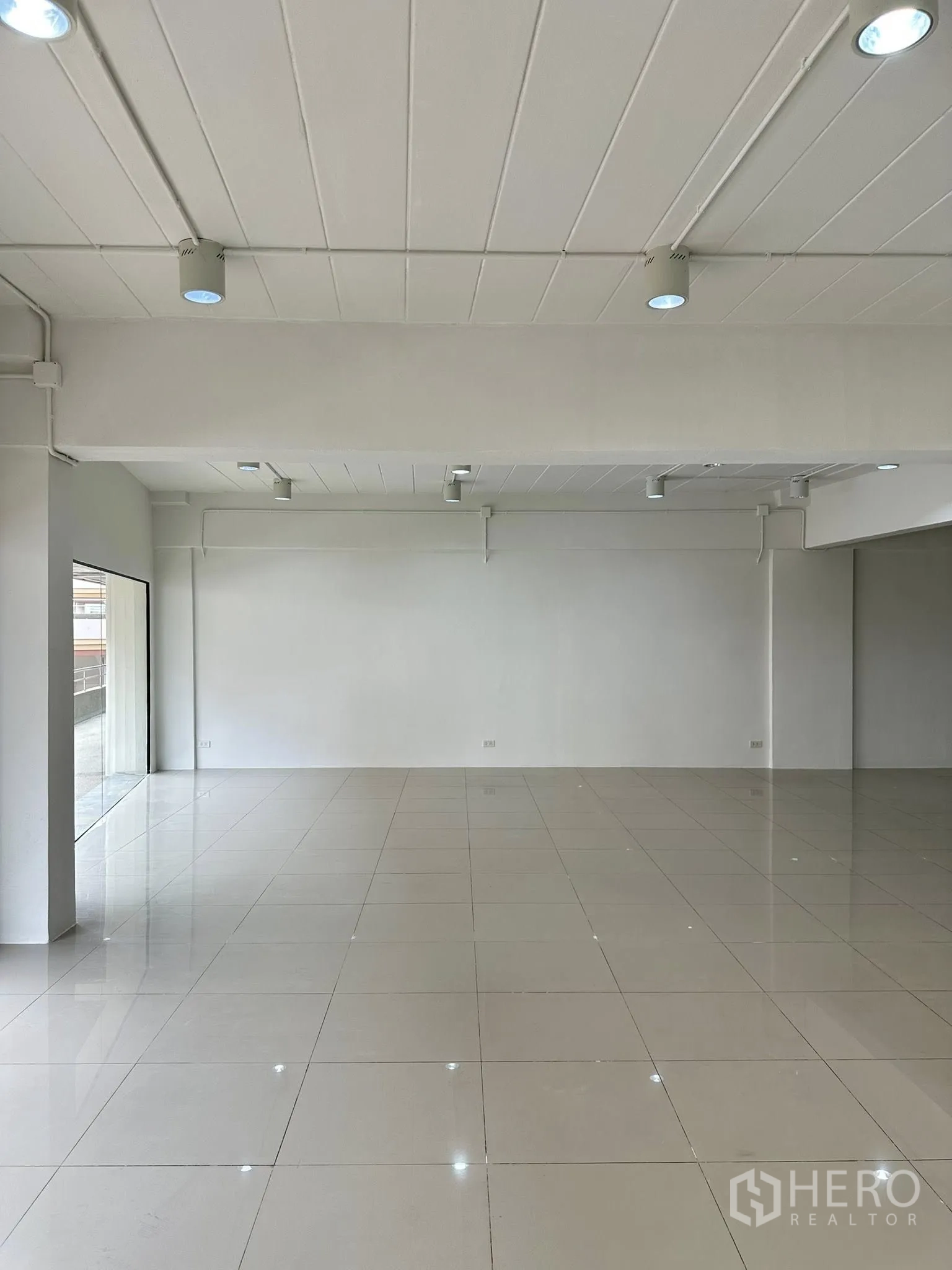 Office Space for rent in Watthana, Bangkok - Spacious white office with a large window wall and glossy floor tiles.