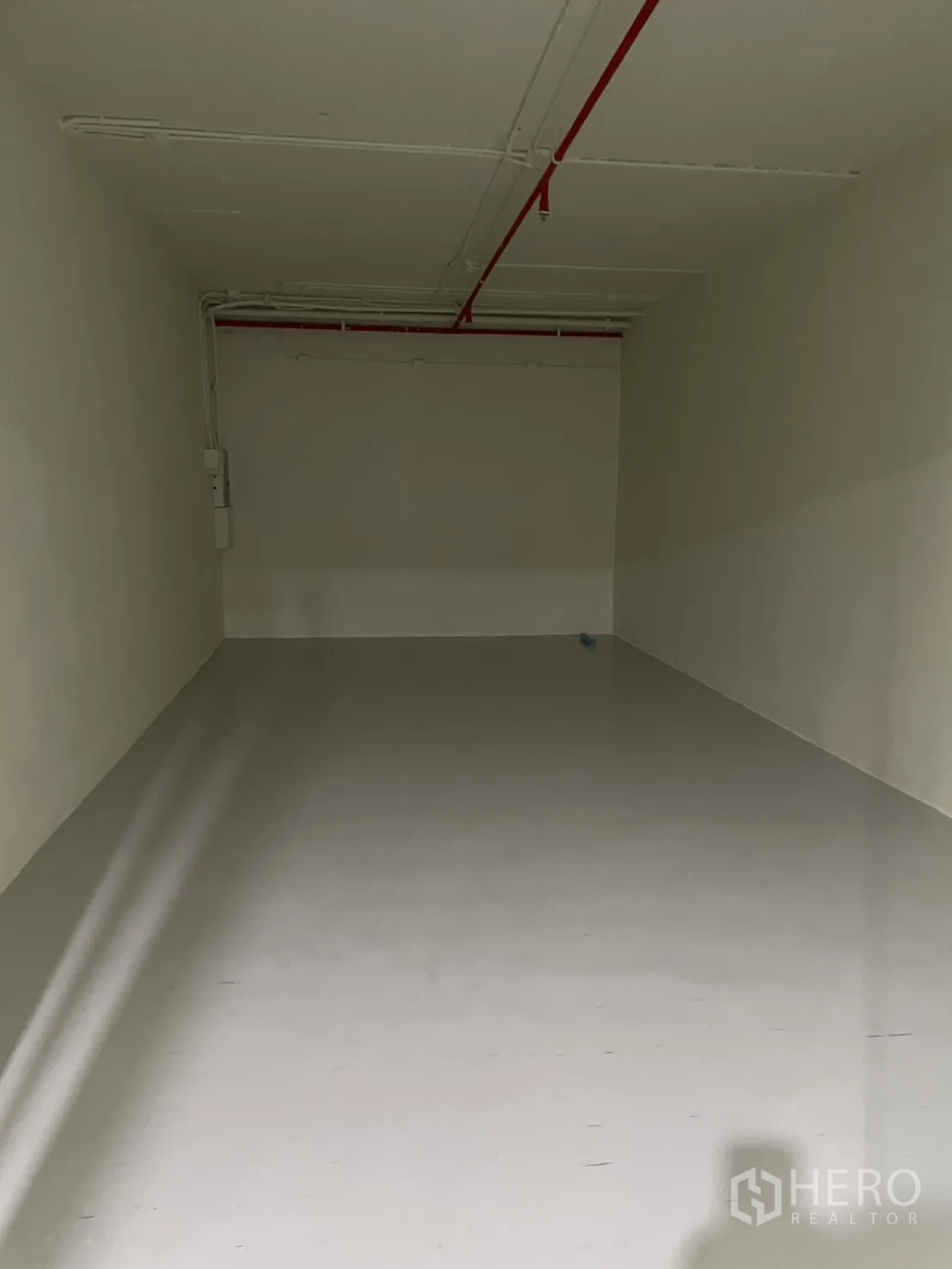 Retail Space for rent in Watthana, Bangkok - Empty rectangular retail unit with white walls, smooth light floor, and exposed red sprinkler pipe on the ceiling.