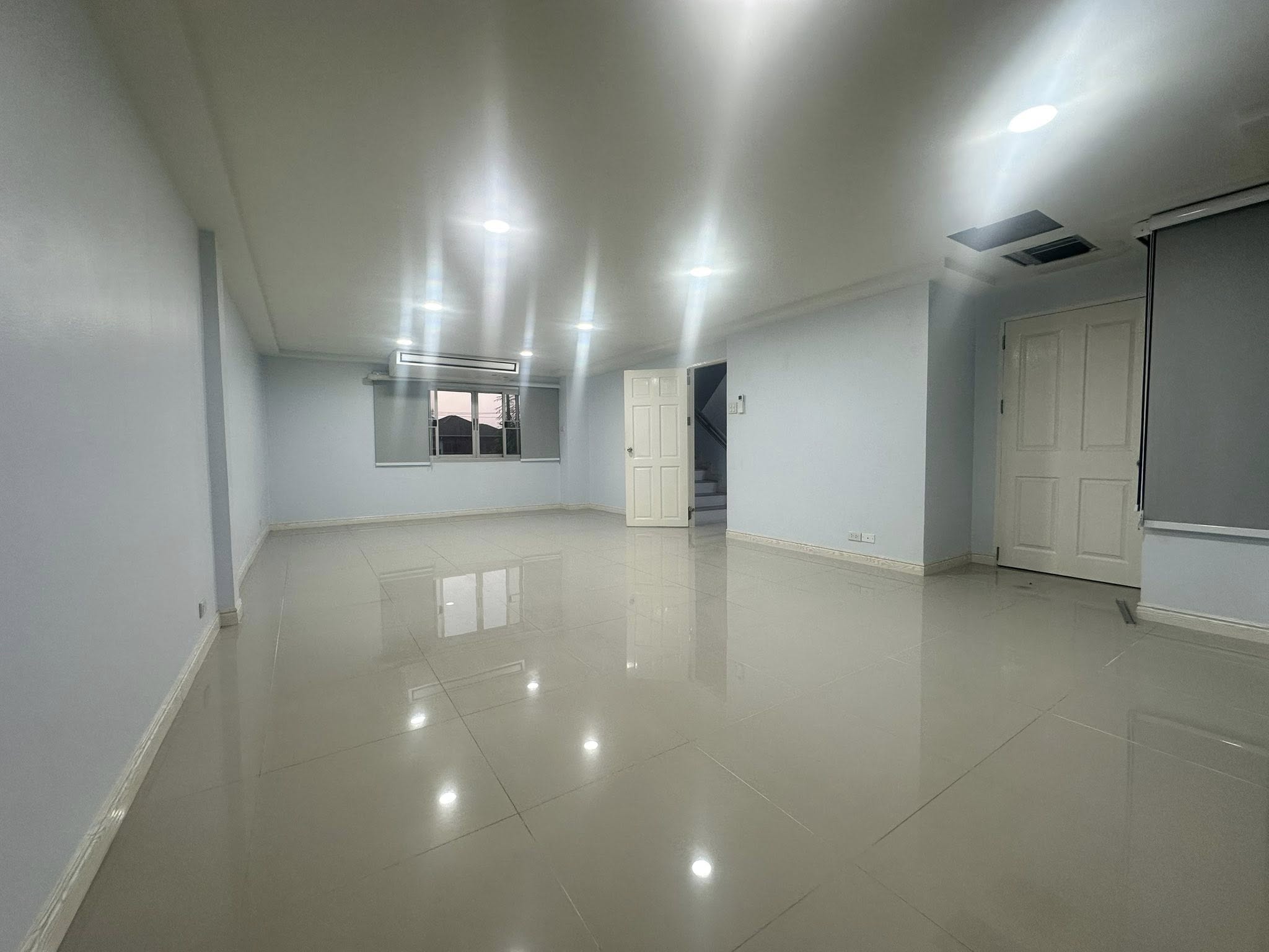 Home Office for rent in Wang Thonglang, Bangkok - Spacious tiled open-plan room with recessed lighting, window and stair access.