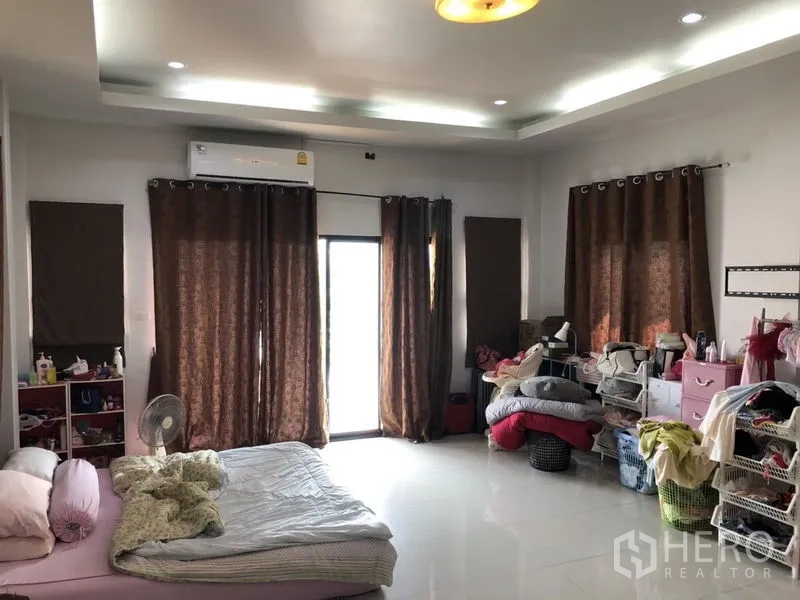 Detached House for sale in Lam Luk Ka, Pathum Thani - Another view of a spacious bedroom with brown curtains and glossy tiles.