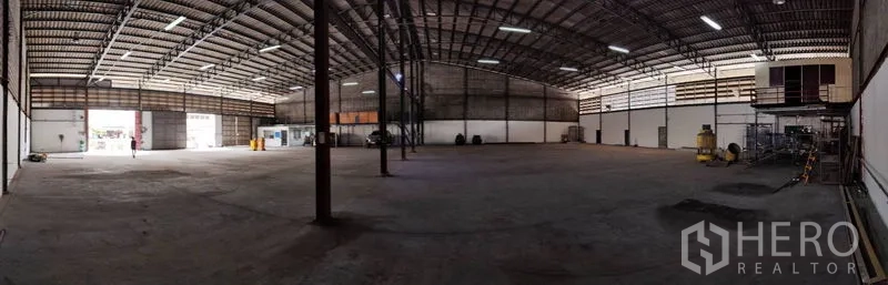 Warehouse for rent in Bang Phli, Samut Prakan - Spacious storage hall with steel columns, open loading bays and bright overhead lights.