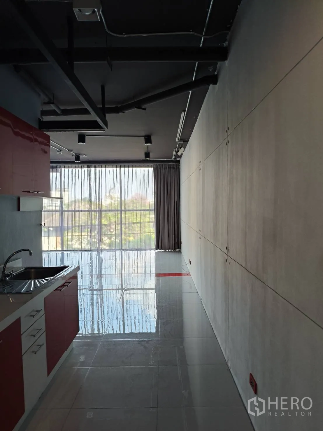 Office Space for rent in Khlong Toei, Bangkok - Kitchenette view through to the open office and large window with exposed ducts overhead.