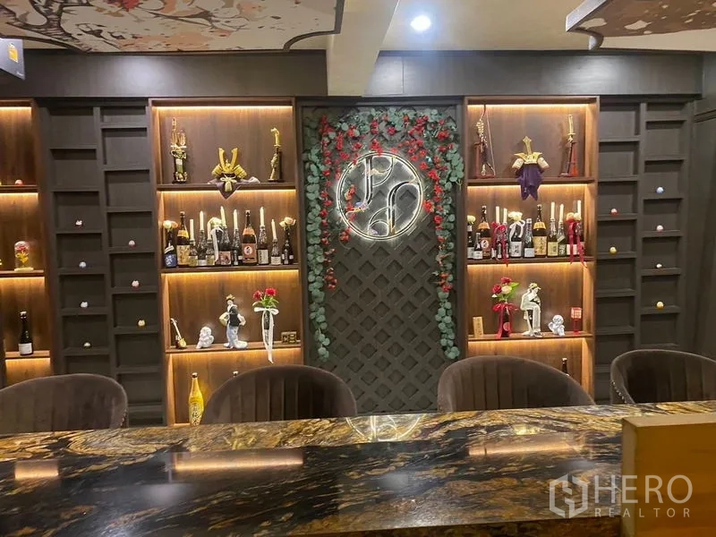 店屋 出租 - 吧台背后的特色展示墙，带灯壁龛与圆形霓虹标。