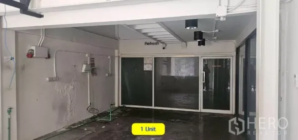 Shophouse for rent in Watthana, Bangkok - Ground-level space with glass partitions, spotlight fixtures, and an under-stair area.