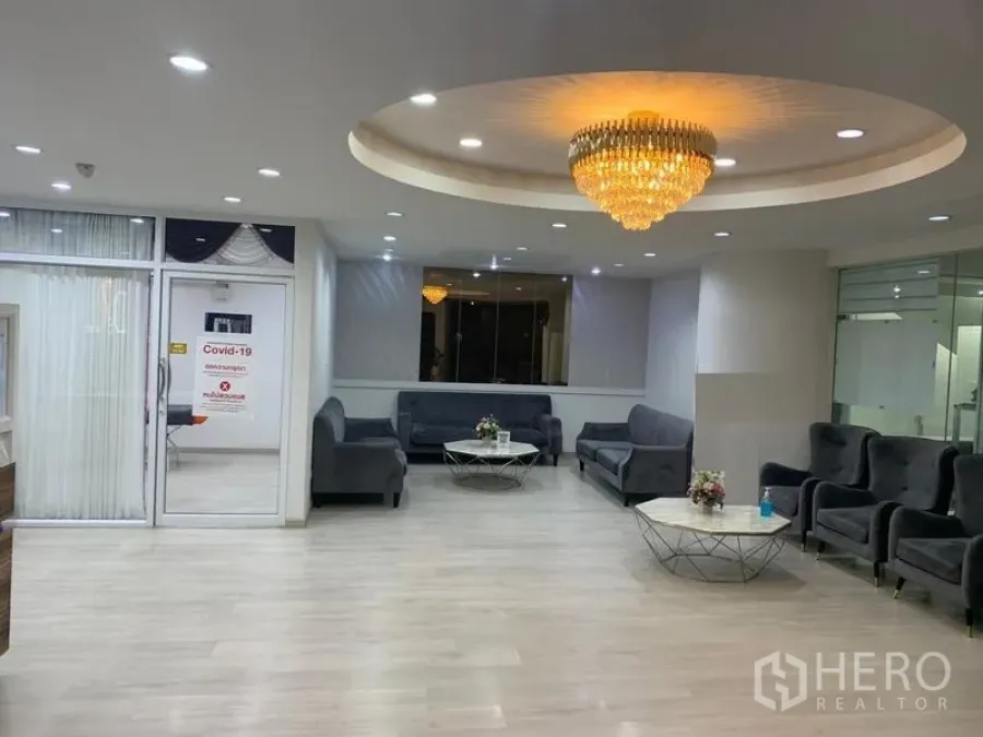 Retail Space for rent in Pathum Wan, Bangkok - Modern lounge with chandelier, grey sofas and round coffee tables in a bright retail space.