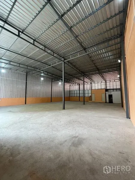 Warehouse for rent in Din Daeng, Bangkok - Spacious warehouse interior with steel truss roof, concrete floor, and LED lighting.