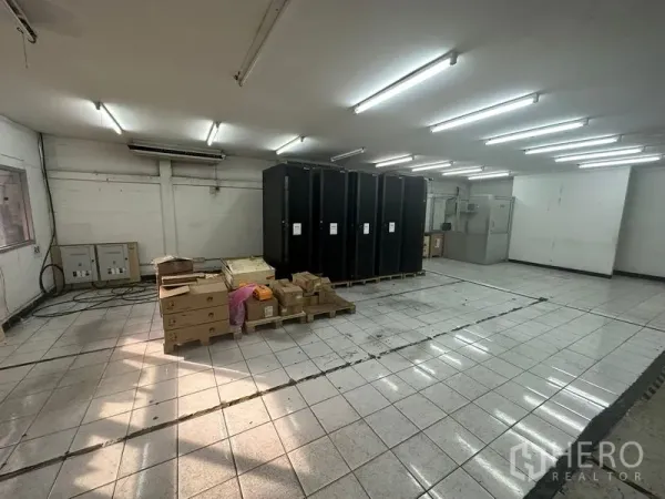 货栈 出租在Khlong Toei, Bangkok - 大型洁净式工作区，顶置照明，瓷砖地面上摆放托盘柜与纸箱。