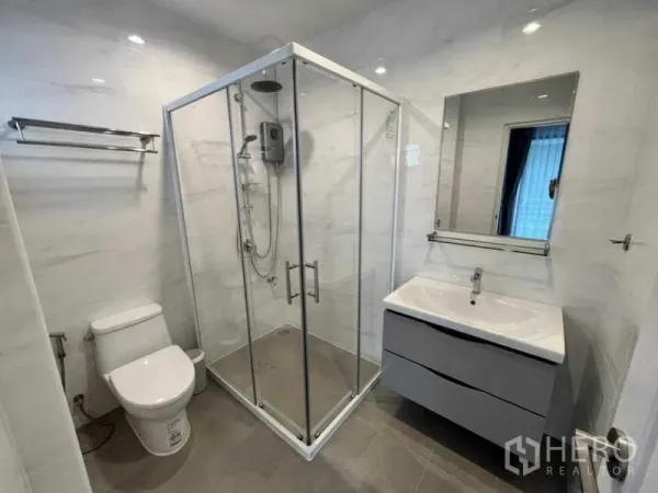 Detached House for rent in Phaya Thai, Bangkok - Modern bathroom with glass-enclosed shower, vanity and toilet.