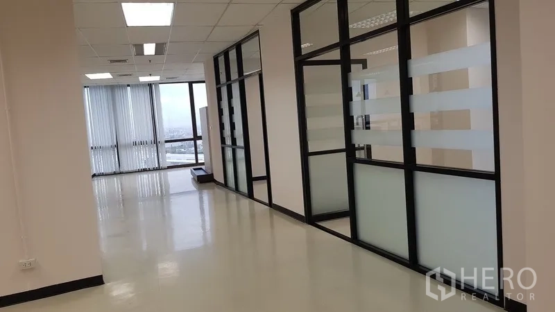 Office Space for rent in Din Daeng, Bangkok - Hallway with glass-partitioned meeting rooms and frosted panels letting in daylight.