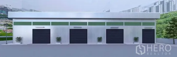 Warehouse for rent in Bang Phli, Samut Prakan - Front elevation of the warehouse featuring four black roller shutter doors and minimal landscaping.