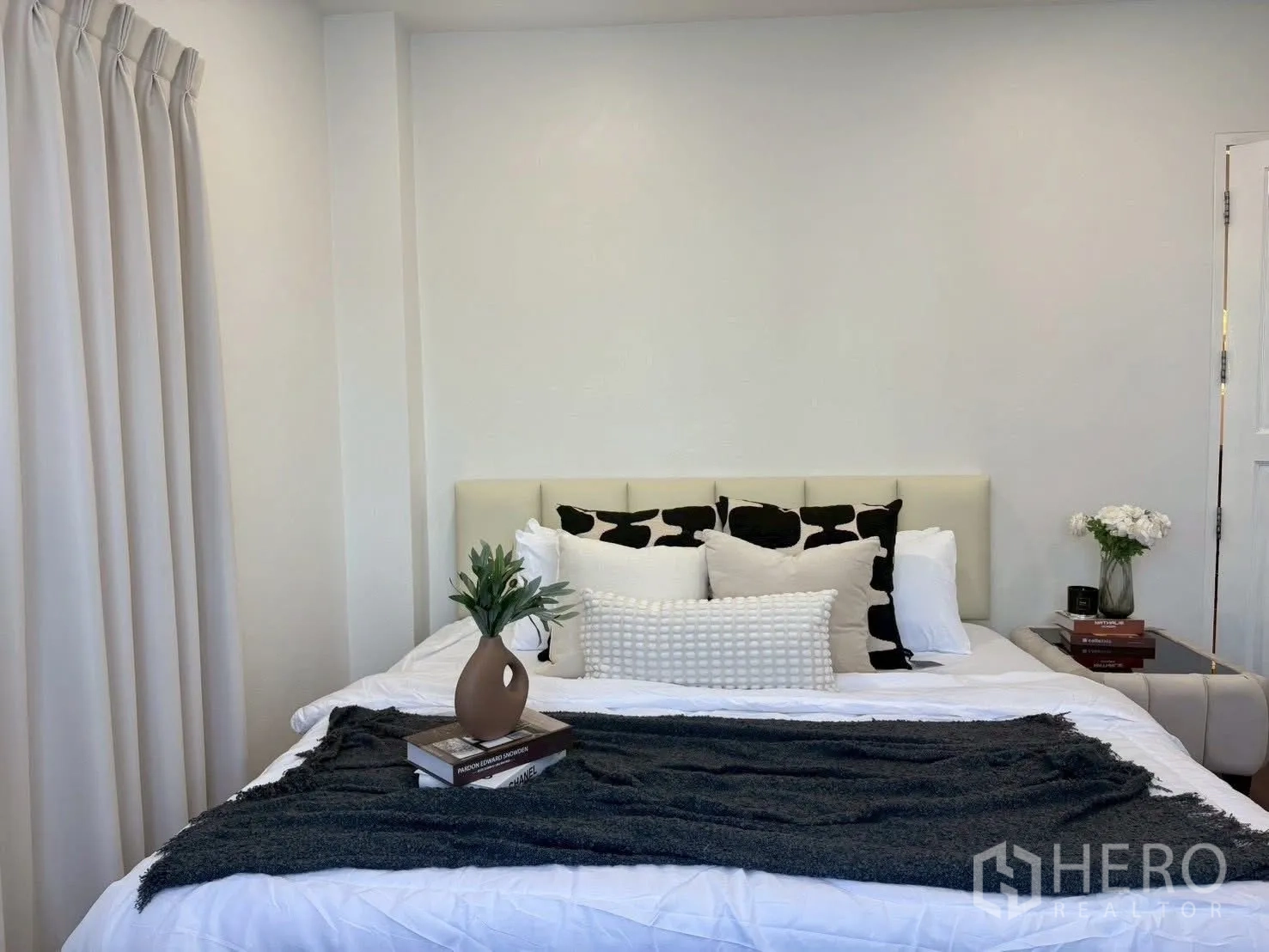Townhouse for rent in Huai Khwang, Bangkok - Bedroom with king bed, layered pillows, and neutral bedding.