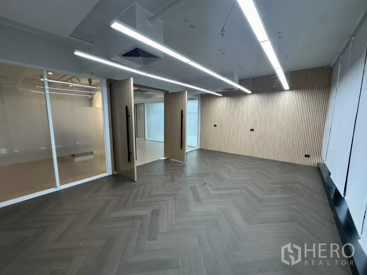 Office Space for rent in Watthana, Bangkok - Boardroom with dark herringbone flooring and folding wooden doors.