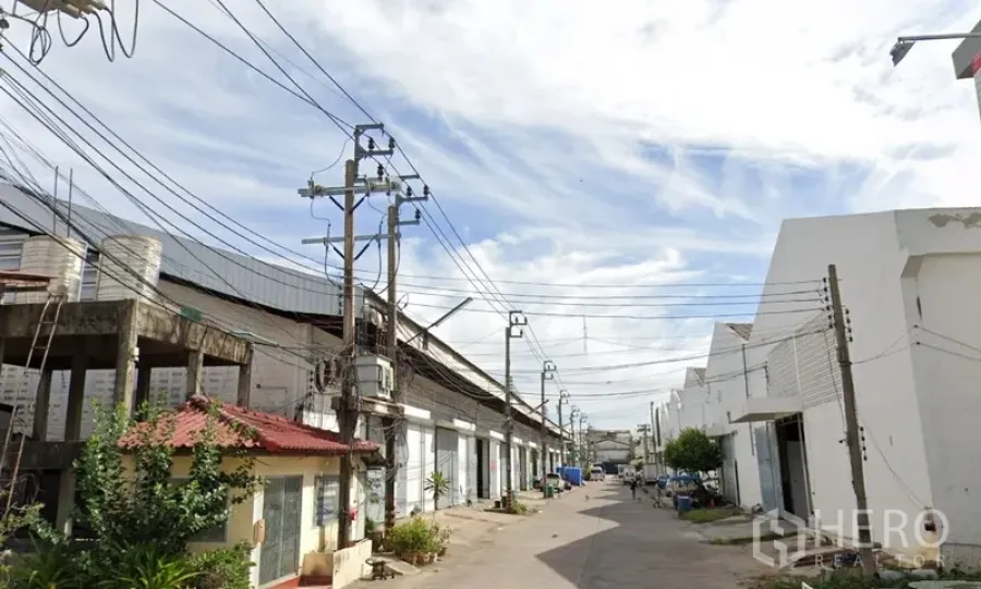 Factory for rent in Samut Prakan - Industrial lane in Phra Pradaeng with rows of warehouses, power lines, and truck access.