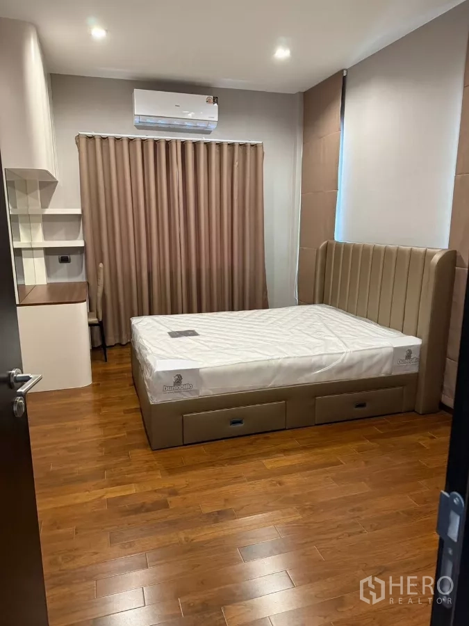 Detached House for rent in Bang Phli, Samut Prakan - Spacious bedroom with bed and study area on wooden flooring