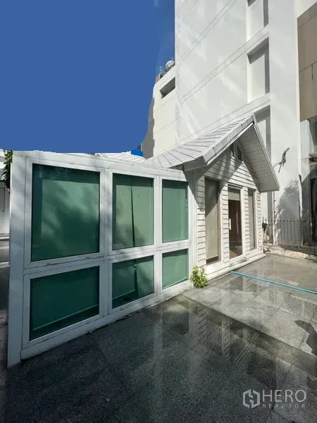 Retail Space for rent in Watthana, Bangkok - Corner view of glass-panel extension and gabled unit next to a high-rise