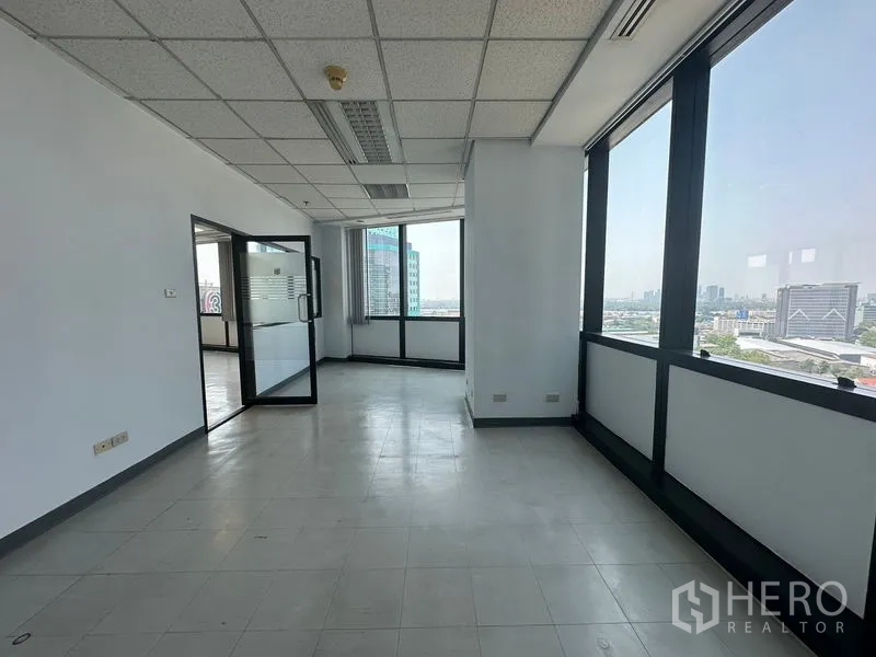 Office Space for rent in Khlong Toei, Bangkok - Light-filled workspace with large windows, door to adjoining office, and skyline outlook.
