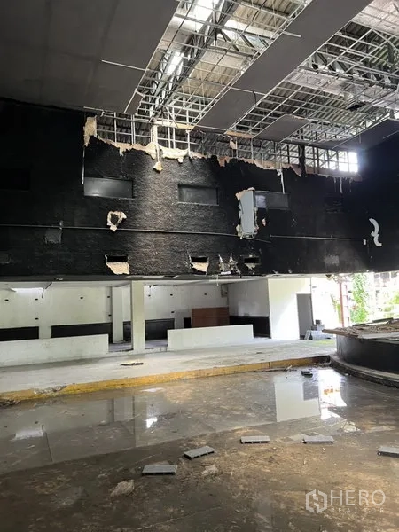 Warehouse for rent in Bang Kapi, Bangkok - High-bay interior showing exposed ceiling grid and service counters with natural light.
