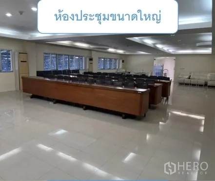 Warehouse for rent in Mueang Pathum Thani, Pathum Thani - Large conference room with rows of tables, chairs and recessed lighting.
