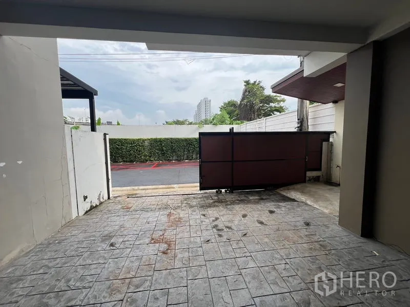 Townhouse for rent or sale in Khlong Toei, Bangkok - Front driveway and sliding gate facing a quiet street.
