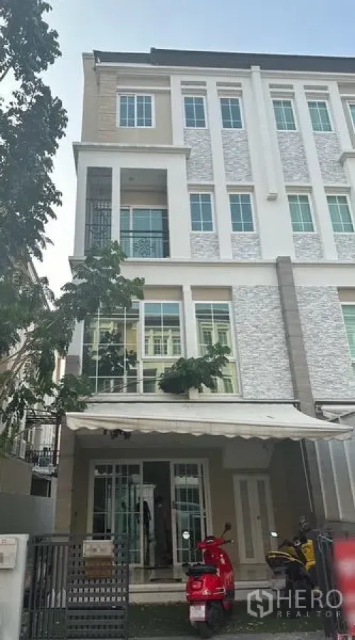 Home Office for rent in Bang Na, Bangkok - Front elevation of the four-storey home office with tree-lined frontage and awning.
