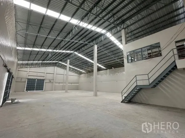 Factory for rent in Lam Luk Ka, Pathum Thani - Production area with mezzanine office windows and metal staircase.