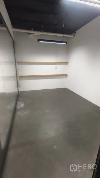 Office Space for rent in Pathum Wan, Bangkok - Compact meeting room with concrete floor, white walls, floating shelves and LED strip lighting.