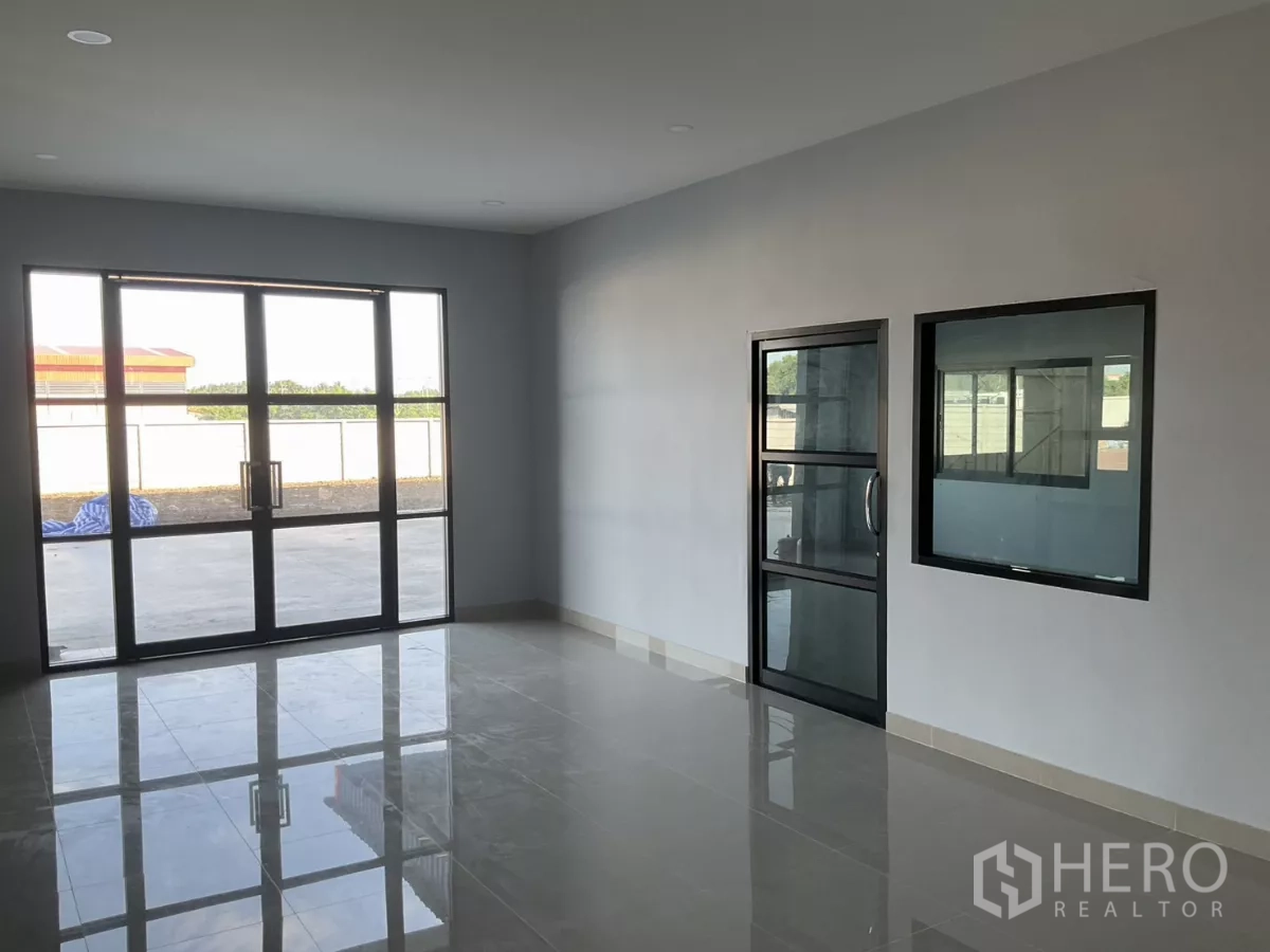 Factory for sale in Samut Sakhon - Ground-floor office lobby with glass double doors and glossy tiled floors.