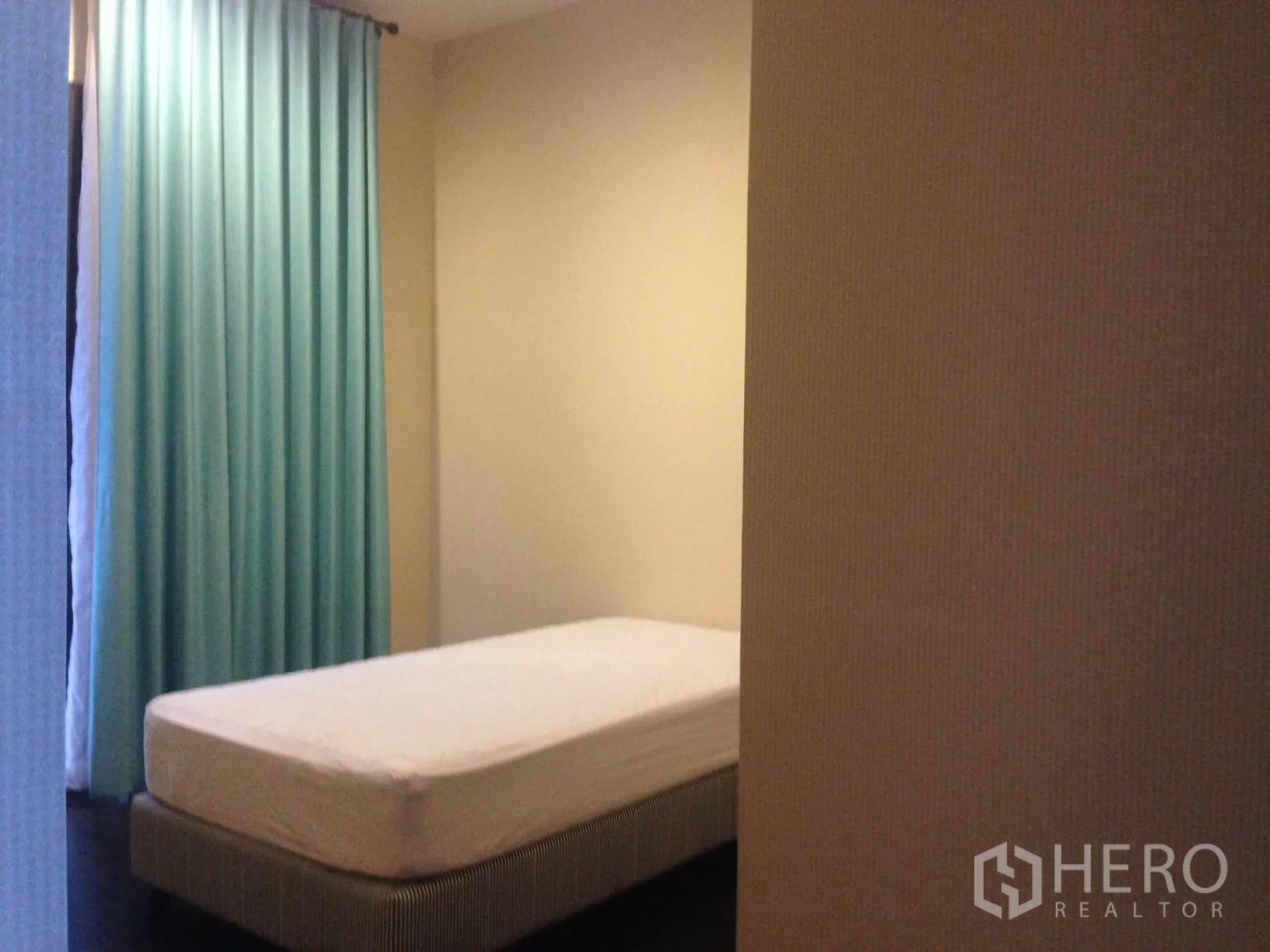 Townhouse for rent in Bang Kapi, Bangkok - Cozy single bedroom with blue curtains and a simple bed set.