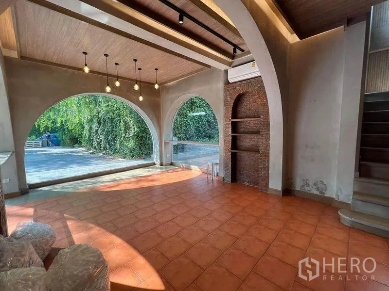 Retail Space for rent in Phaya Thai, Bangkok - Open retail hall with arched glass, brick niche, and tiled floor.