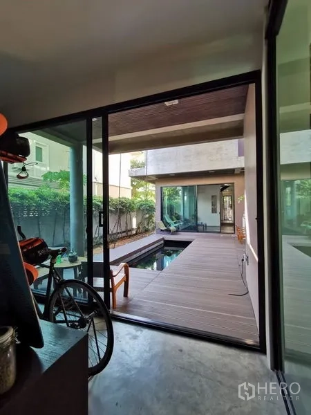 带办公室的家 出售在Wang Thonglang, Bangkok - 推拉玻璃门通向木质庭院，设景观水池与休闲座位。