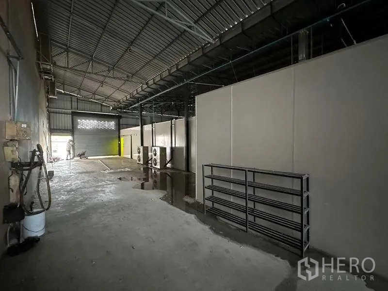 Warehouse for rent in Khlong Luang, Pathum Thani - High-roof warehouse aisle with partitions and roller shutter access.