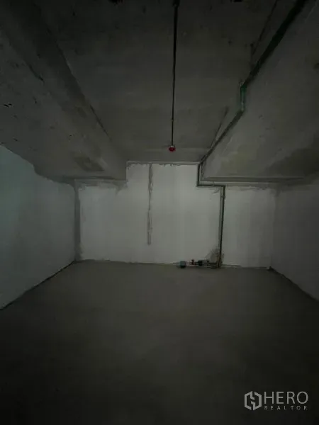 Retail Space for rent in Pathum Wan, Bangkok - Empty back room with concrete walls and ceiling, showing utility lines.