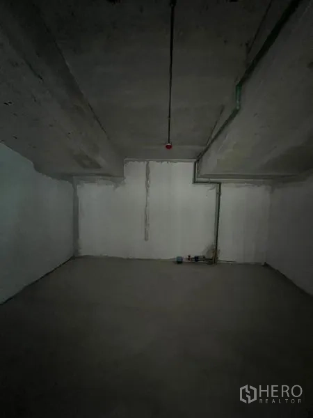 Retail Space for rent in Pathum Wan, Bangkok - Empty back room with concrete walls and ceiling, showing utility lines.