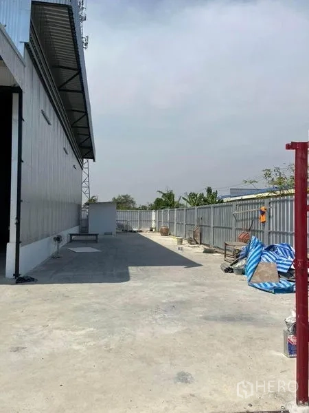 คลังสินค้า ให้เช่าในNonthaburi - ทางวิ่งคอนกรีตข้างโกดังผนังเมทัลชีท พร้อมรั้วรอบและลานขนถ่ายสินค้า ไทรน้อย นนทบุรี
