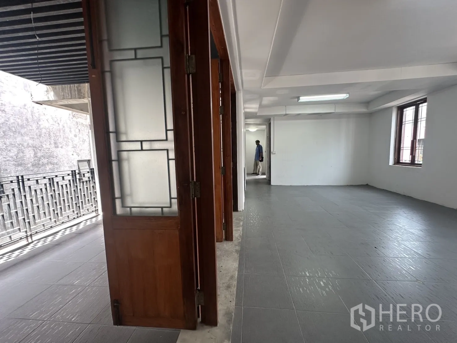 Home Office for rent in Pathum Wan, Bangkok - Corridor beside folding frosted-glass doors leading into a spacious office room.