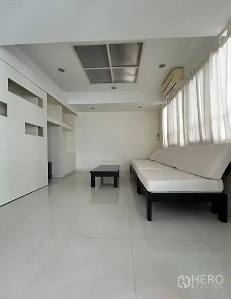 Home Office for rent in Suan Luang, Bangkok - Minimal lounge or meeting room with sofa and white built-ins.