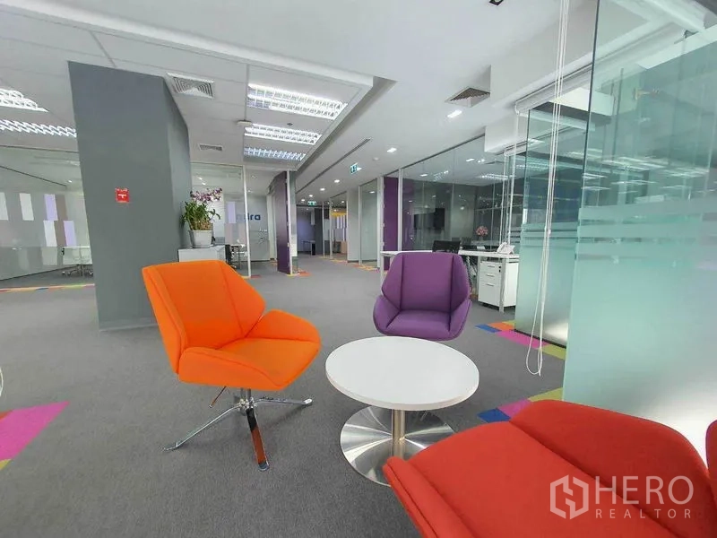 Office Space for rent in Ratchathewi, Bangkok - Casual breakout lounge with bright armchairs and a round table beside a glass wall.