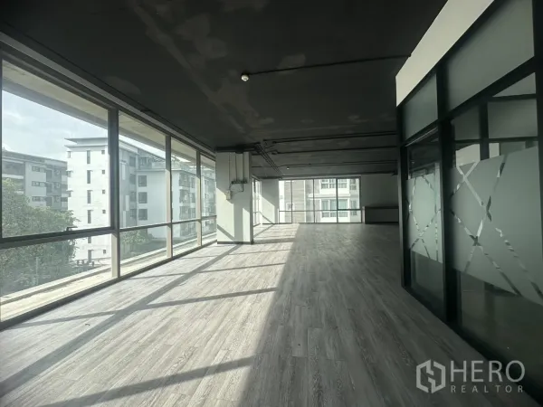 Office Space for rent in Khlong Toei, Bangkok - Sunlit open‑plan office with floor‑to‑ceiling windows and grey vinyl floors in Khlong Toei.