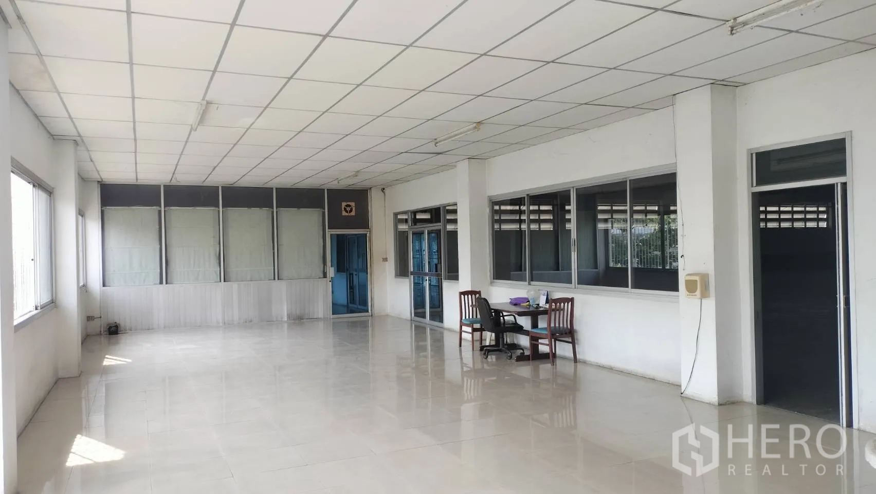 Factory for rent in Lat Krabang, Bangkok - Bright office space with tiled floors, wide windows, and simple desks.