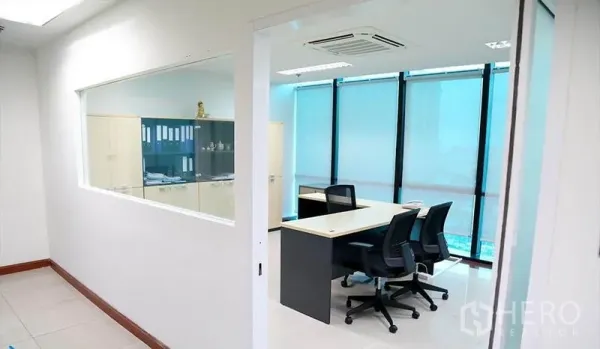 办公空间 出租在Huai Khwang, Bangkok - 玻璃隔断的独立办公室，靠近蓝色遮光落地窗的书桌