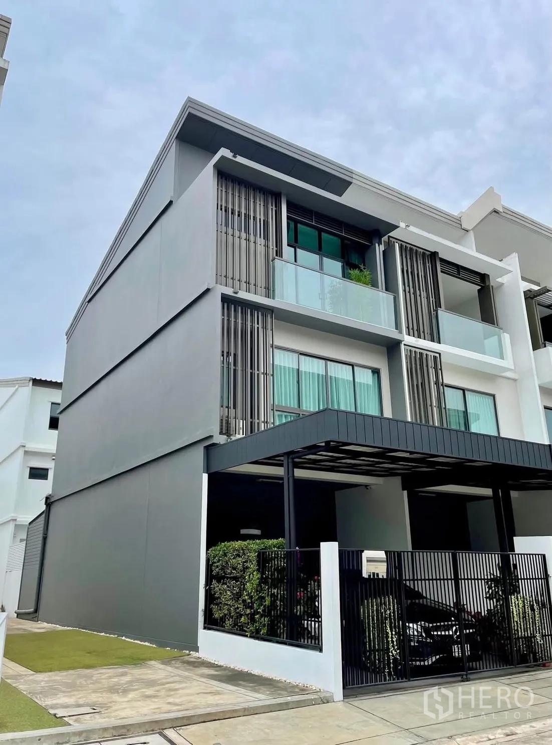 联排别墅 for rent in Lat Phrao, Bangkok - 现代三层联排别墅外立面，带阳台与车棚。