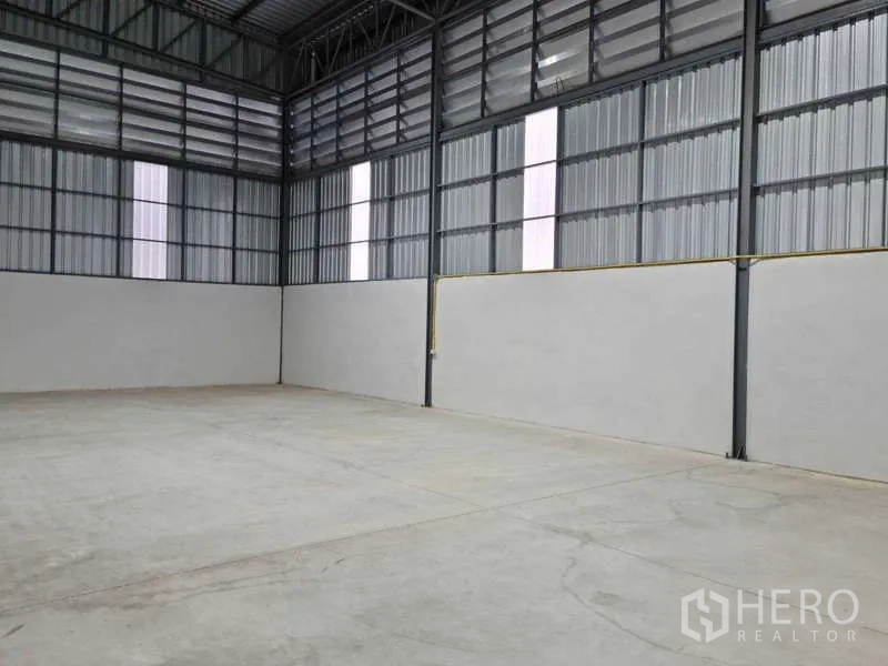 Warehouse for rent in Bang Bua Thong, Nonthaburi - Clear span warehouse bay with high walls, light panels and ventilated cladding.