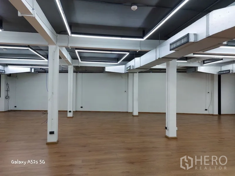 带办公室的家 出租在Khlong Toei, Bangkok - 空置办公区，木地板、白色承重柱和方形LED顶灯。