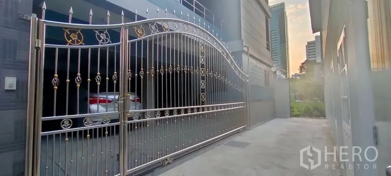 Home Office for rent in Pathum Wan, Bangkok - Stainless-steel security gate and driveway leading to covered parking.