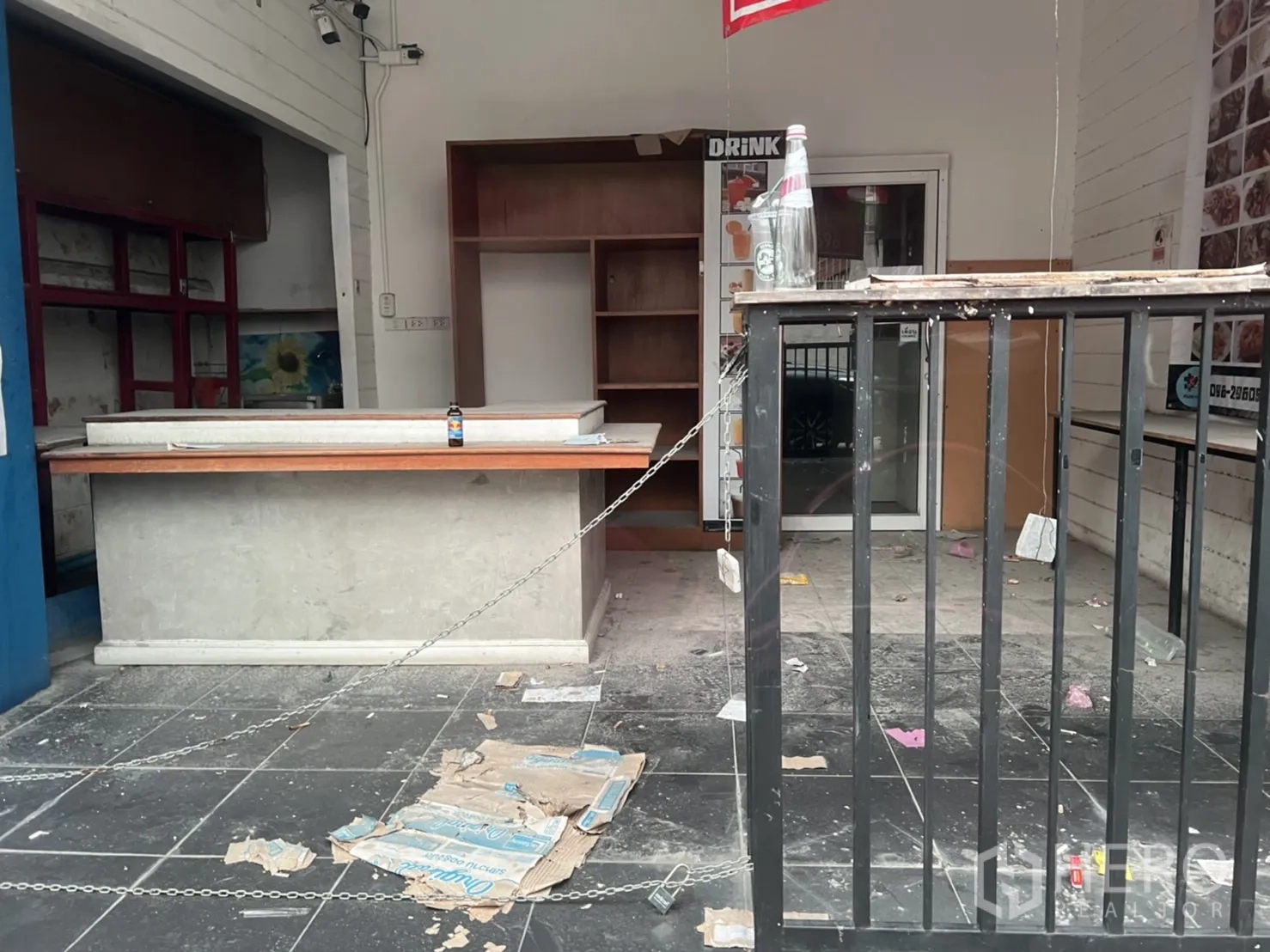 零售空间 出租或出售在Watthana, Bangkok - 空置零售单元内景，设服务吧台、置物架与金属护栏，瓷砖地面。