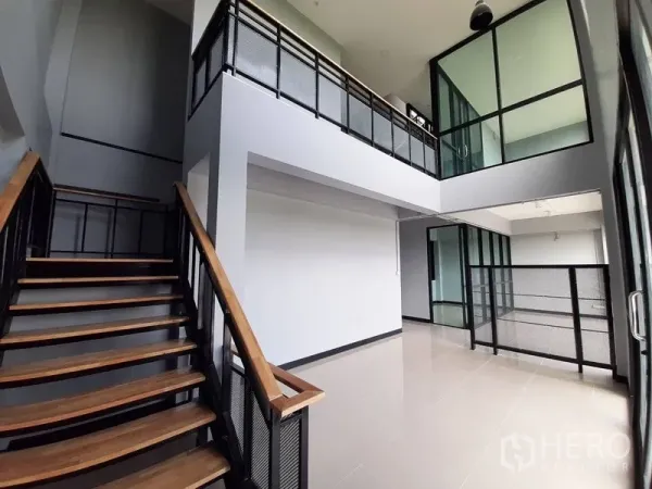 Factory for rent or sale in Lam Luk Ka, Pathum Thani - Wood-tread staircase leading to glass-partitioned office mezzanine.