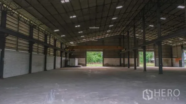 Factory for rent in Bang Phli, Samut Prakan - Wide clear-span factory space with high clearance and rear loading opening to a green yard.
